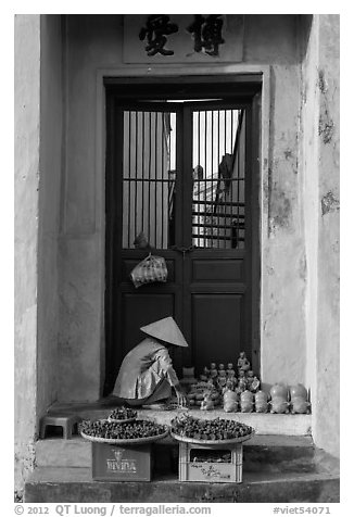 Ceramics vendor, blue temple door. Hoi An, Vietnam (black and white)