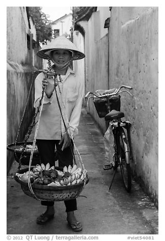 Fruit vendor carrying bananas. Hoi An, Vietnam (black and white)