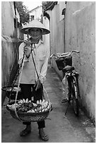 Fruit vendor carrying bananas. Hoi An, Vietnam (black and white)