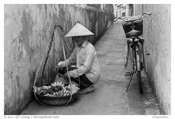 Fruit vendor in narrow alley. Hoi An, Vietnam (black and white)