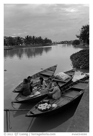 Family having dinner on boats at dusk. Hoi An, Vietnam (black and white)