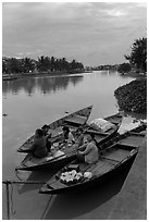 Family having dinner on boats at dusk. Hoi An, Vietnam (black and white)