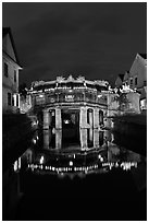 Illuminated Japanese covered bridge reflected in canal. Hoi An, Vietnam ( black and white)