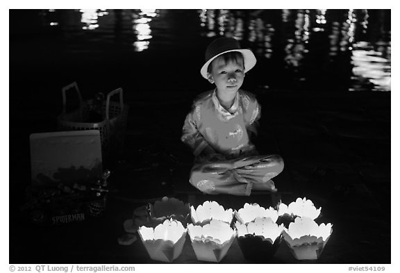 Boy selling candle lanterns at night. Hoi An, Vietnam (black and white)