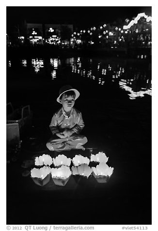 Boy selling candle lanterns by the river. Hoi An, Vietnam