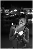Woman holding candle box at night. Hoi An, Vietnam (black and white)