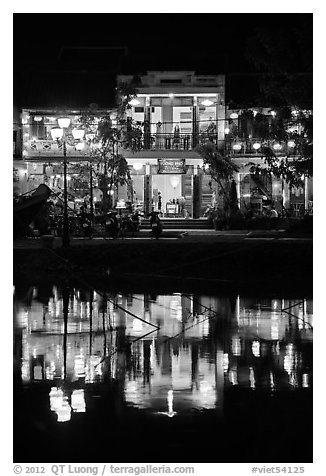 Waterfront house reflected in river at night. Hoi An, Vietnam