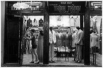 Woman closing doors of taylor shop. Hoi An, Vietnam ( black and white)