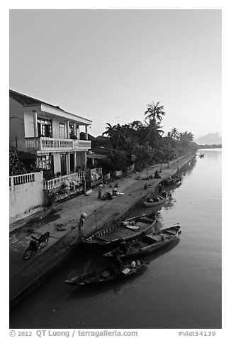 Waterfront and quay with vendors at sunrise. Hoi An, Vietnam (black and white)