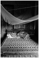 Wooden bed with straw mat and mosquito net, Cam Kim Village. Hoi An, Vietnam (black and white)