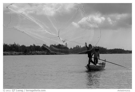 Fisherman throwing net, Thu Bon River. Hoi An, Vietnam