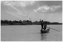 Fisherman throwing net, Thu Bon River. Hoi An, Vietnam (black and white)