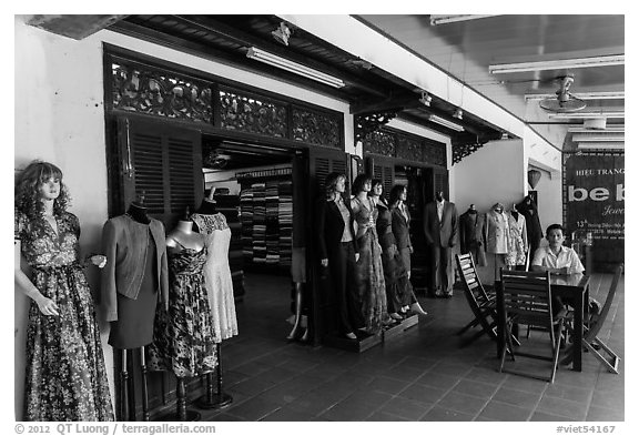 Man sitting outside textile store. Hoi An, Vietnam (black and white)