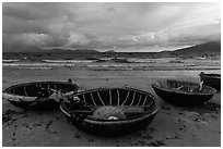 Coracle boats on beach during storm. Da Nang, Vietnam (black and white)