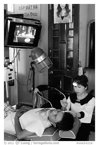 Man getting ear cleaning. Vietnam (black and white)