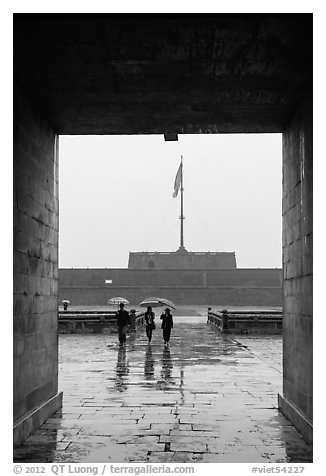 Tourists with unbrellas and flag monument, citadel. Hue, Vietnam (black and white)