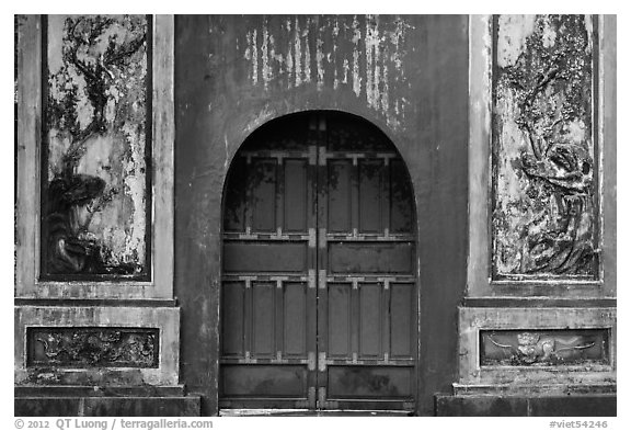 Red door and ceramic decorations, imperial citadel. Hue, Vietnam (black and white)