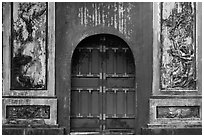 Red door and ceramic decorations, imperial citadel. Hue, Vietnam ( black and white)