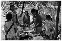 Woman preparing donuts near canal. Hue, Vietnam (black and white)