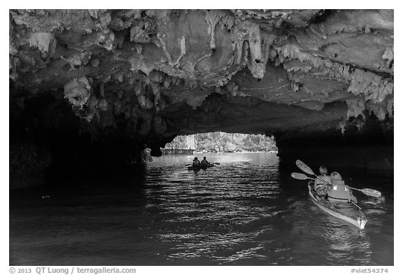 Paddling through Luon Cave tunnel. Halong Bay, Vietnam (black and white)