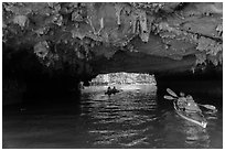 Paddling through Luon Cave tunnel. Halong Bay, Vietnam (black and white)