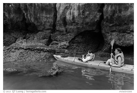 Sea kayakers approaching monkey. Halong Bay, Vietnam (black and white)