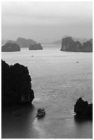 Tour boat navigating between islets. Halong Bay, Vietnam ( black and white)