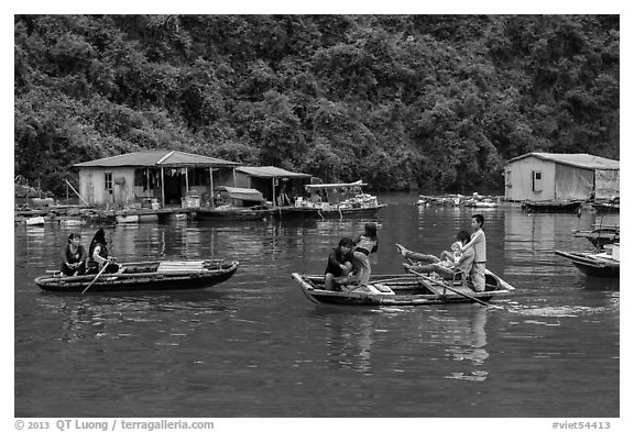 Villagers move between floating houses by rowboat. Halong Bay, Vietnam (black and white)