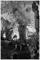 Tourists in first grotto, Surprise Cave. Halong Bay, Vietnam ( black and white)