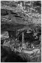 Tourists walking in cavernous chamber, Sungsot cave. Halong Bay, Vietnam (black and white)