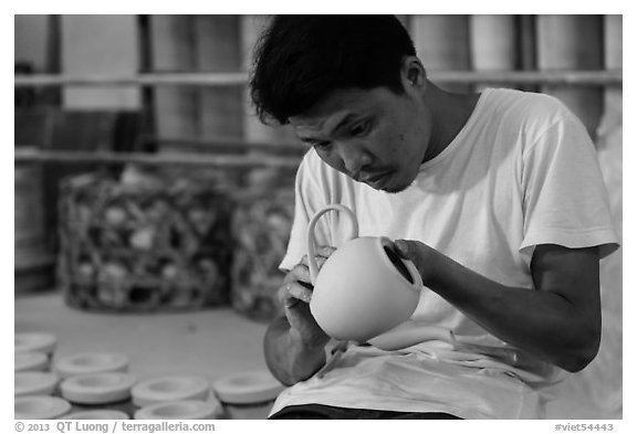 Man assembling ceramic tea pot in workshop. Bat Trang, Vietnam (black and white)