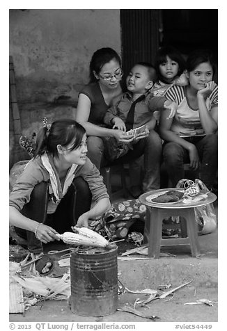 Woman roasting corn in the street. Bat Trang, Vietnam (black and white)