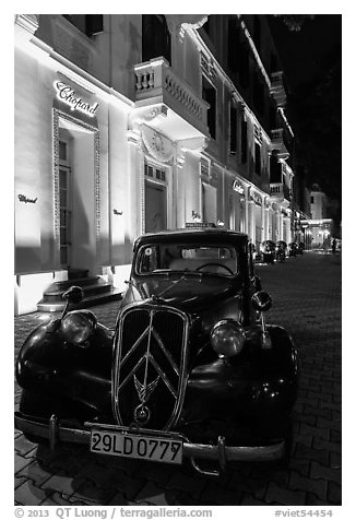Vintage car in front of Metropole hotel at night. Hanoi, Vietnam (black and white)