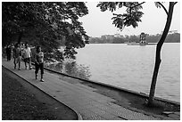 Walking for exercise around Hoang Kiem Lake at dawn. Hanoi, Vietnam (black and white)