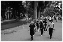 Numerous people walk counter-clockwise around Hoang Kiem Lake. Hanoi, Vietnam (black and white)