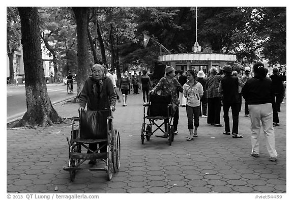 Elderly women pushing their wheelchairs while walking for exercise. Hanoi, Vietnam (black and white)