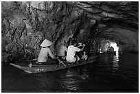 Boat rowed inside grotto passage, Trang An. Ninh Binh,  Vietnam (black and white)