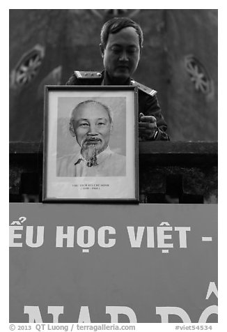 Officer hanging a picture of Ho Chi Minh, Hanoi Citadel. Hanoi, Vietnam (black and white)