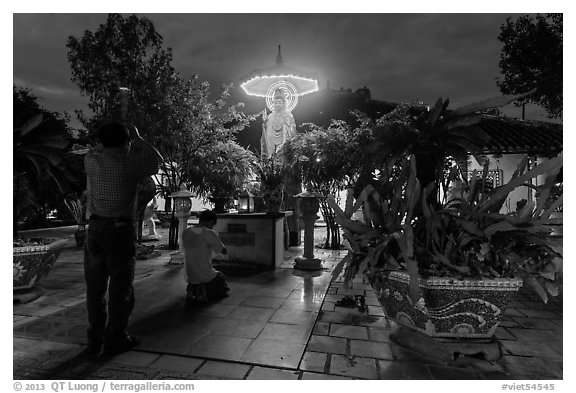 Men pray at outside Phung Son Pagoda at night, district 11. Ho Chi Minh City, Vietnam