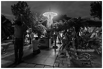 Men pray at outside Phung Son Pagoda at night, district 11. Ho Chi Minh City, Vietnam (black and white)