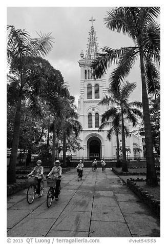 Students biking past Cho Quan Church, district 11. Ho Chi Minh City, Vietnam (black and white)