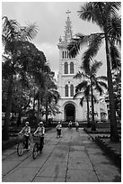 Students biking past Cho Quan Church, district 11. Ho Chi Minh City, Vietnam (black and white)