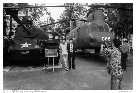Tourists pose with tanks and helicopters, War Remnants Museum, district 3. Ho Chi Minh City, Vietnam (black and white)