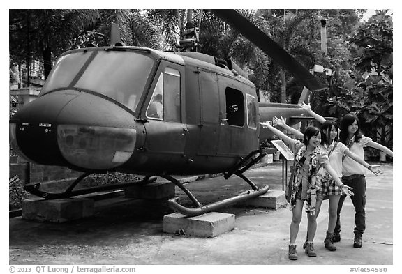 Young women posing with helicopter, War Remnants Museum, district 3. Ho Chi Minh City, Vietnam (black and white)