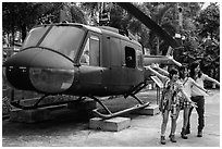 Young women posing with helicopter, War Remnants Museum, district 3. Ho Chi Minh City, Vietnam (black and white)