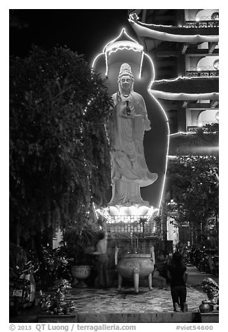 Praying outside Quoc Tu Pagoda at night, district 10. Ho Chi Minh City, Vietnam