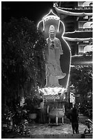 Praying outside Quoc Tu Pagoda at night, district 10. Ho Chi Minh City, Vietnam (black and white)
