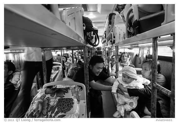 Couple passing baby on sleeper bus. Vietnam