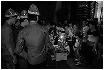 People gather around street hawker on Christmas eve. Ho Chi Minh City, Vietnam ( black and white)