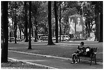 Relaxing on a public bench in park. Ho Chi Minh City, Vietnam (black and white)